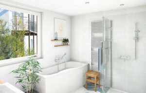 Das moderne weiße Badezimmer mit kreativem Flair ist mit einer Badewanne, einer Glasdusche, einem beheizten Handtuchhalter, einem kleinen Holzhocker, einer Topfpflanze und einem Regal ausgestattet. Ein großes Fenster lässt natürliches Licht herein und gibt den Blick auf Bäume und Gebäude frei.